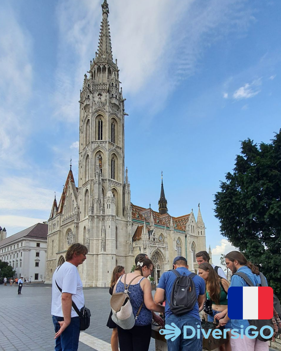 Le guide touristique de DiversiGO parle à notre groupe de touristes des détails clés qui peuvent être observés sur le modèle tactile de la place de la Trinité avec l'église Matthias.