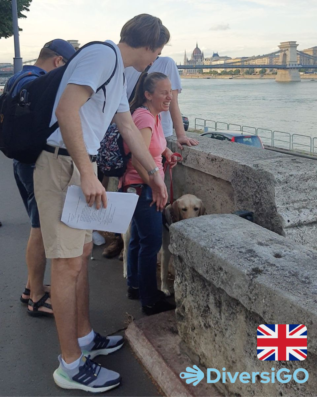 DiversiGO's guide is showing a tactile minisculpture of a classic Hungarian movie to a tourist at the riverside of the Danube.