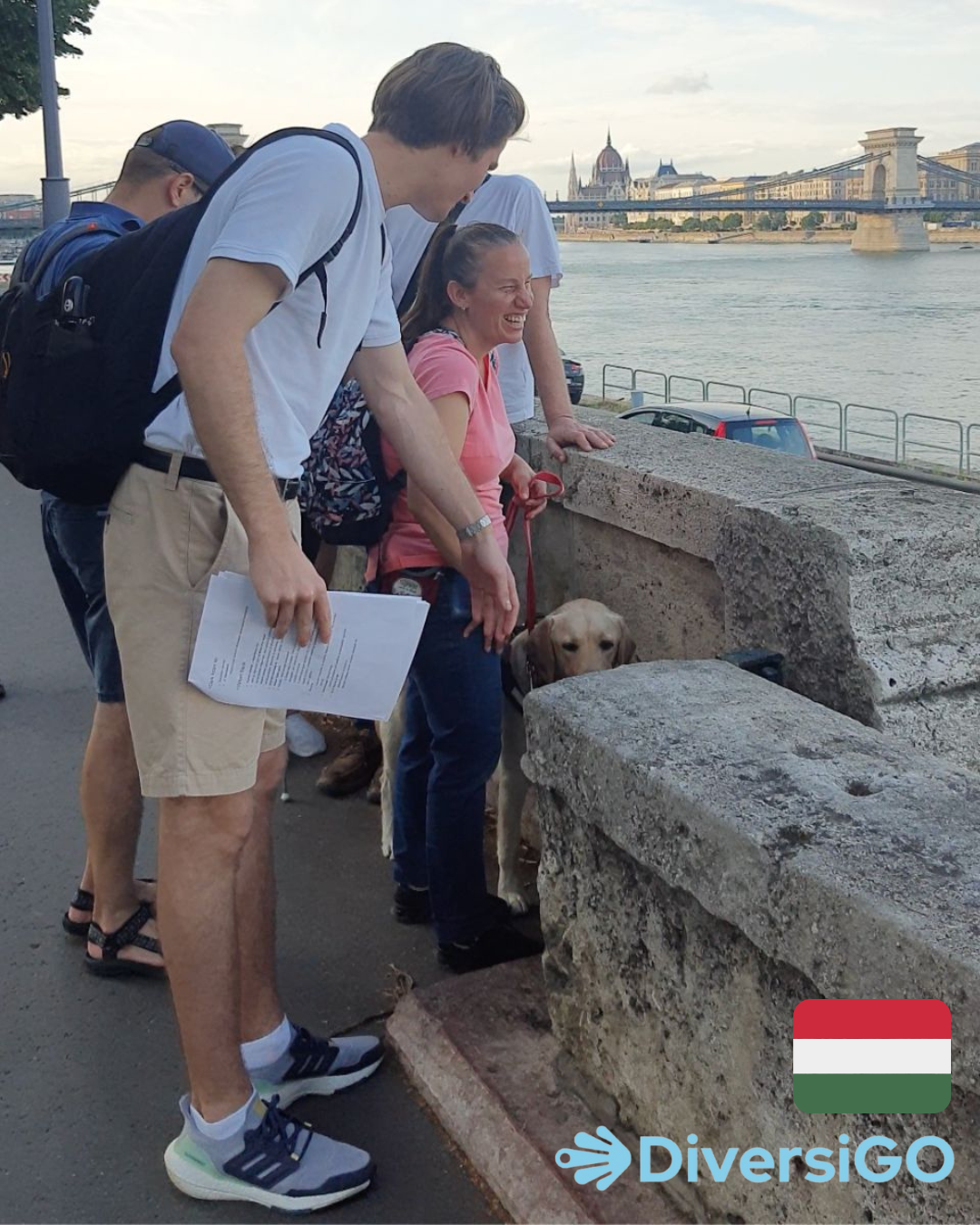 A DiversiGO sétavezetője egy klasszikus magyar filmet ábrázoló tapintható miniszobrot mutat egy turistának a Duna-parton.