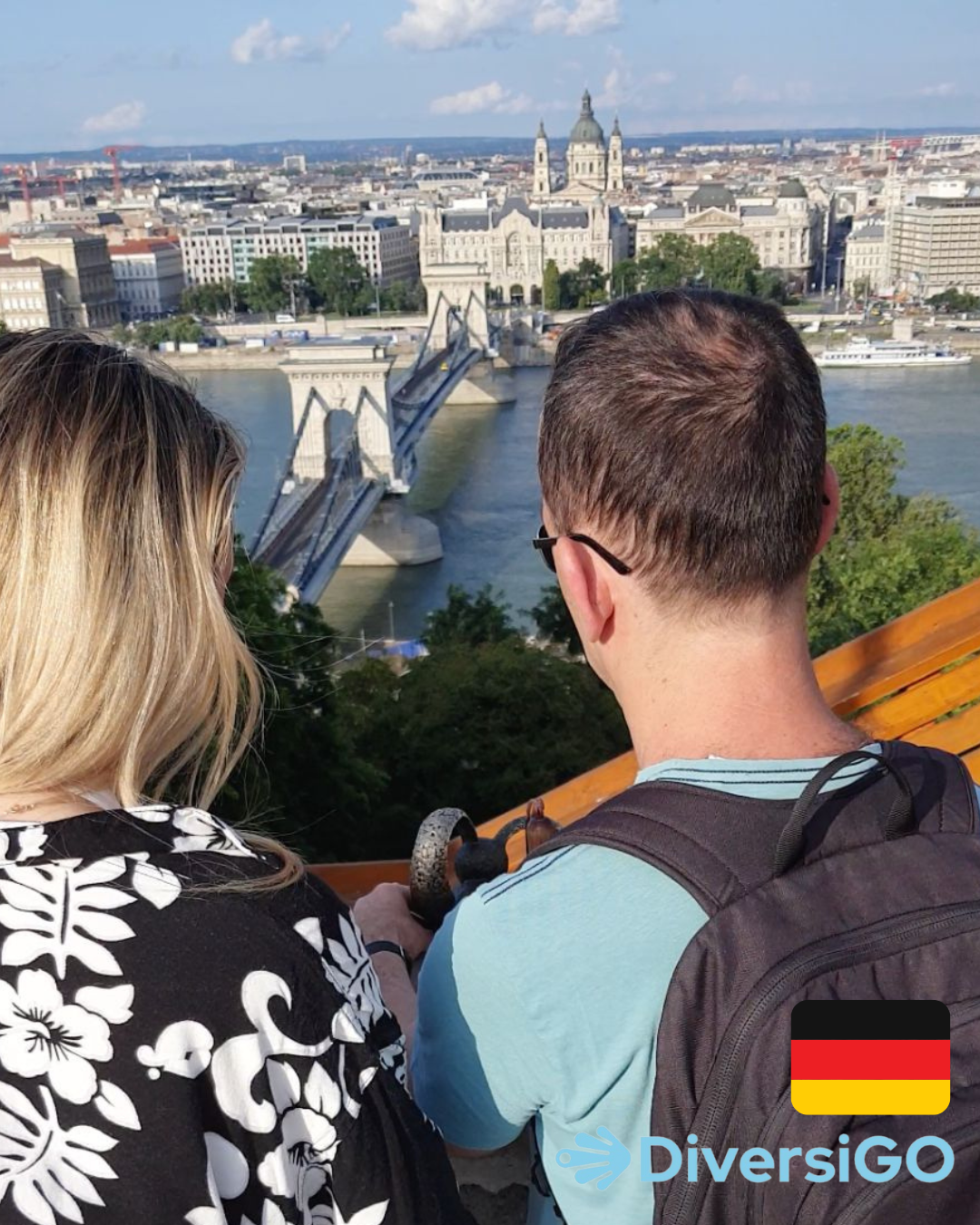 Der Reiseleiter von DiversiGO zeigt einem Touristen die taktile Miniaturskulptur einer berühmten ungarischen Zeichentrickfigur, „Das Kaninchen mit den karierten Ohren“, an einer Stelle, von der aus man einen Panoramablick auf Budapest mit der Donau hat.