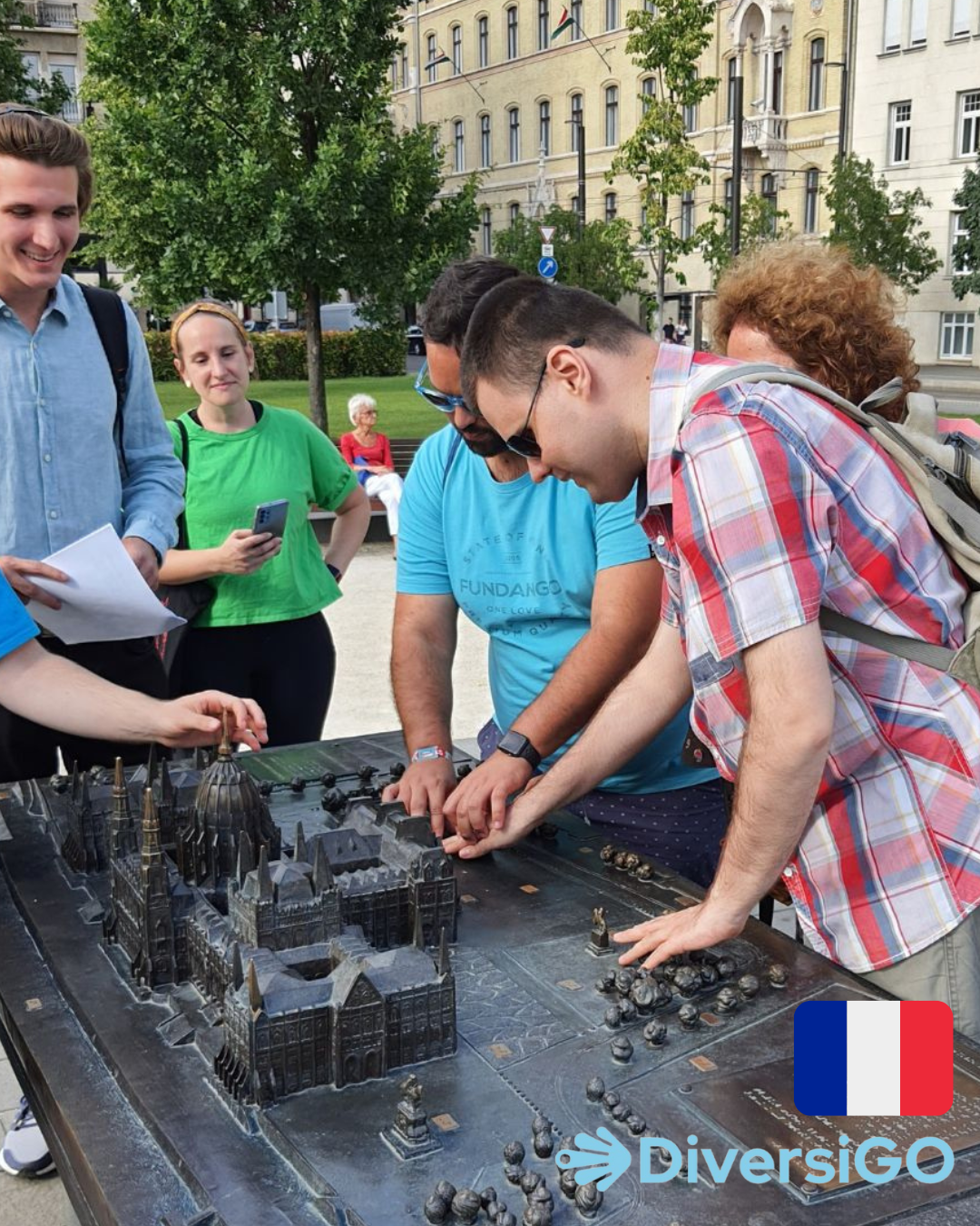 Les touristes observent les dimensions de la maquette tactile du bâtiment du Parlement hongrois et de ses environs.