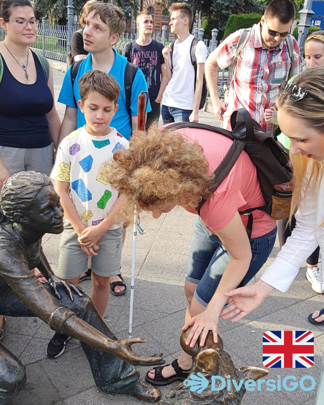 DiversiGO's guide is helping the tourists to observe the lifelike tactile statue of a girl playing with her dog.