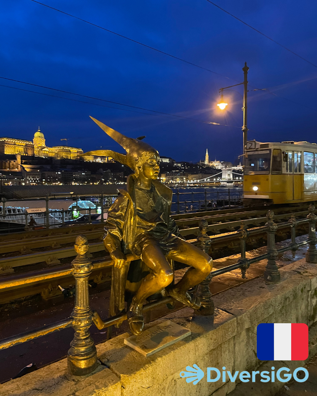 La sculpture tactile populaire d'une fille habillée en princesse portant des accessoires faits maison où en arrière-plan se trouve le célèbre tramway 2 avec le magnifique panorama au bord du Danube le soir.